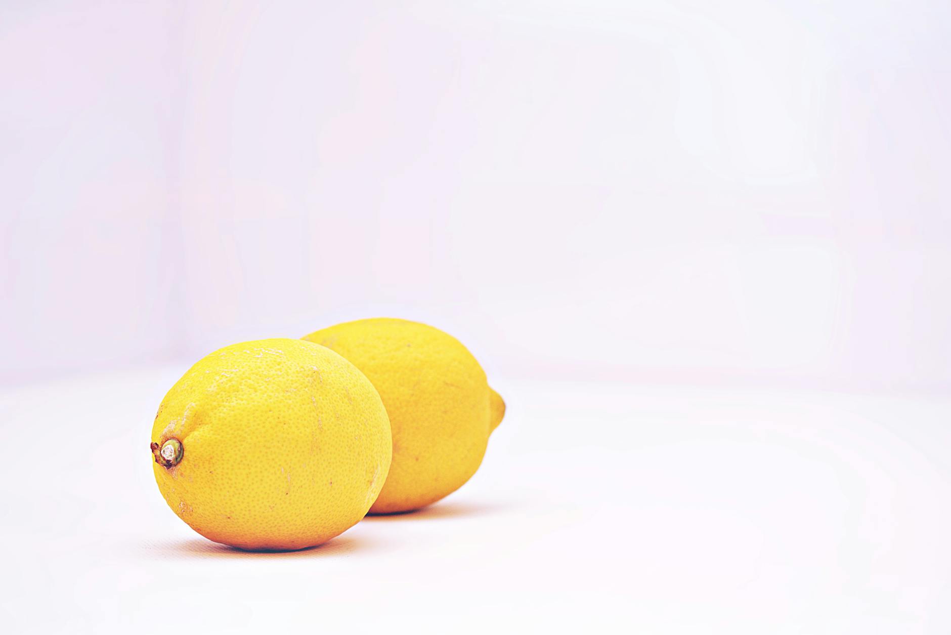 Two vibrant lemons against a white background, representing freshness and sensory clarity