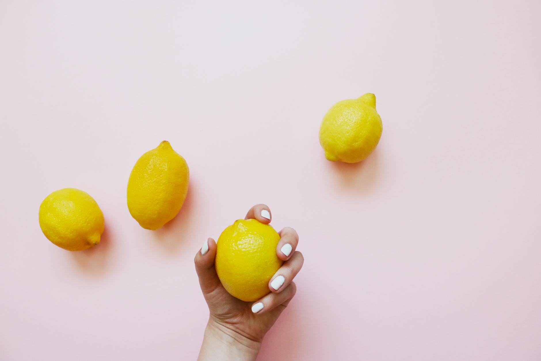 Fresh lemon on a soft pink background, symbolizing gentle healing and recovery