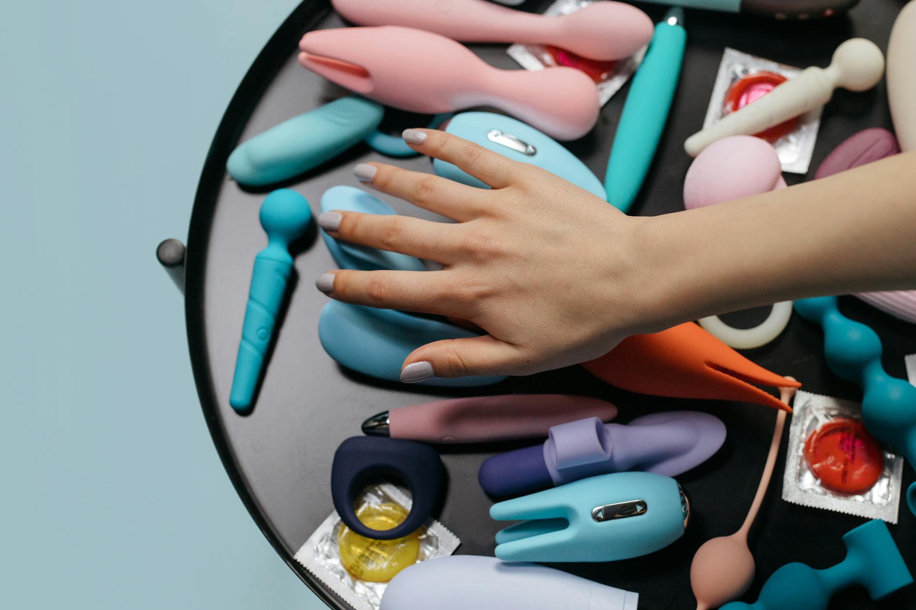 A lemon-colored silicone vibrator held in hand, representing clitoral pleasure and sensation recovery.